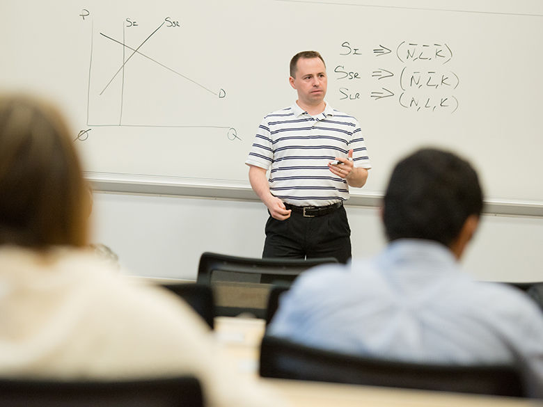 teacher at front of class in front of white board