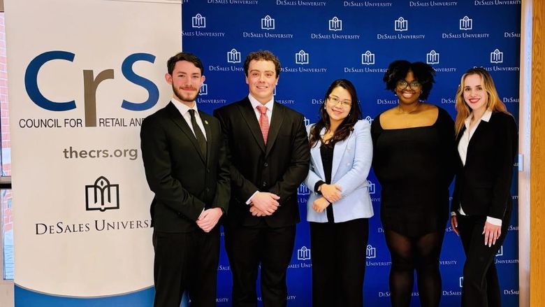 Professor Emily Pham poses for a photo with her four students who participated in a business competion at DeSales University