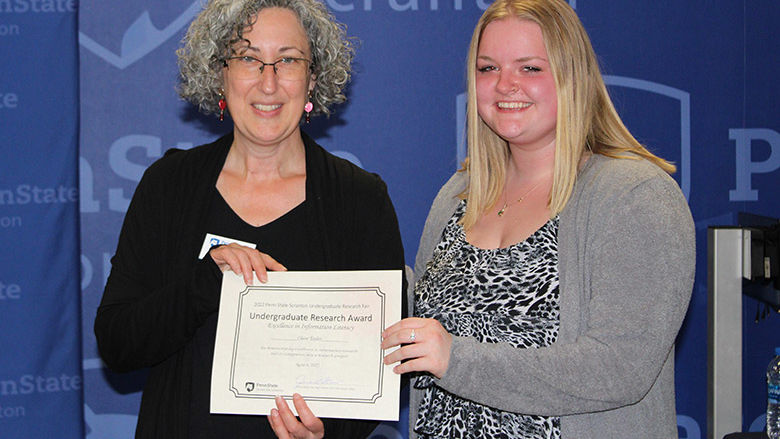 Clair Taylor accepts her award from Librarian Jennie Knies