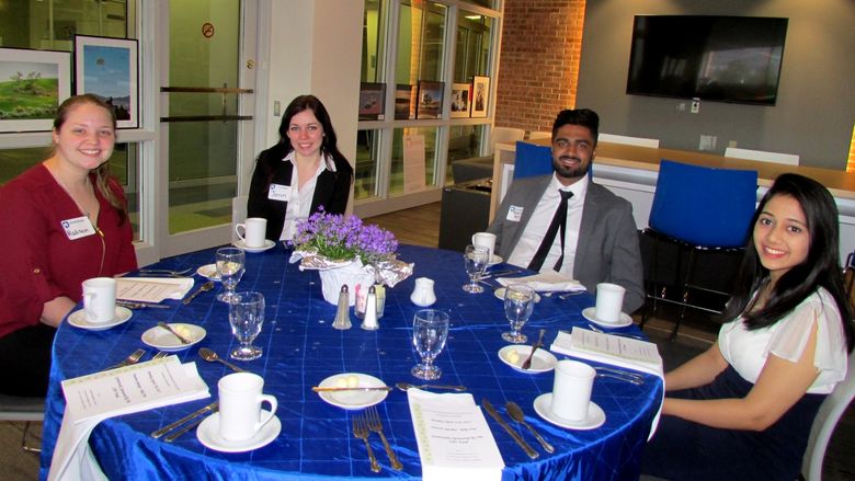 A group of students at a table at the etiquette dinner