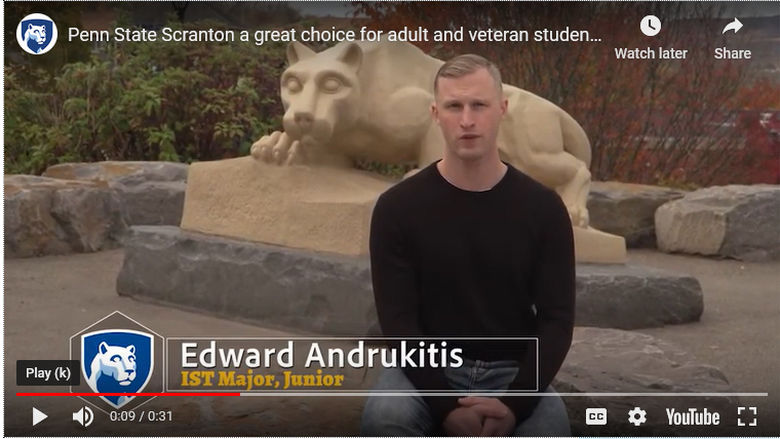 veteran student sits in front of lion shrine statue