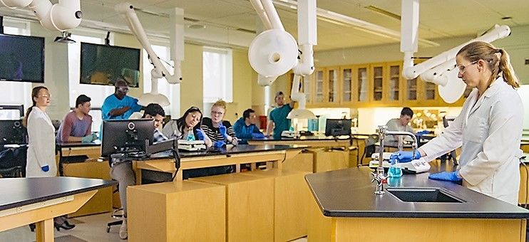 students in chemistry lab with instructor working in a group